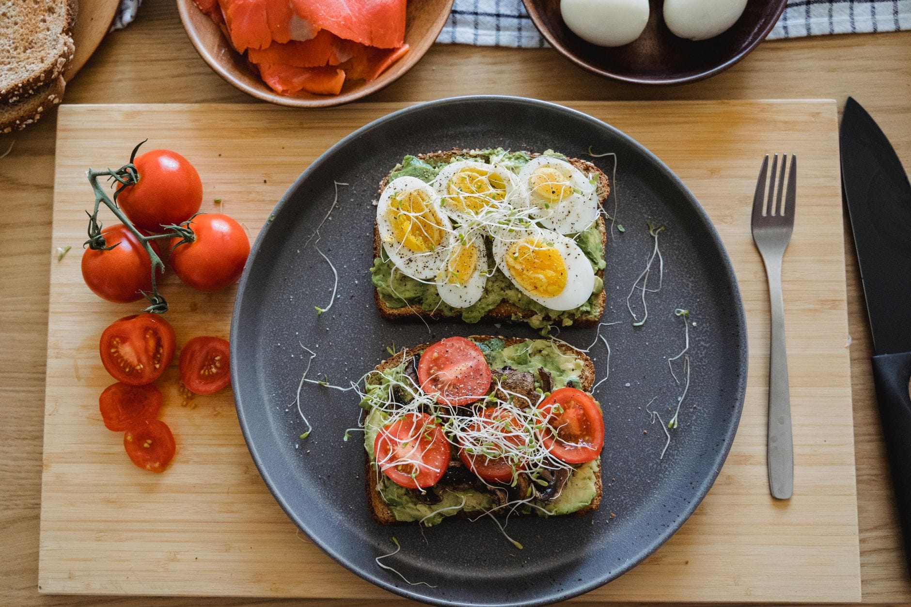 Toasted dark bread topped with mashed avocado and chili flakes on a plate