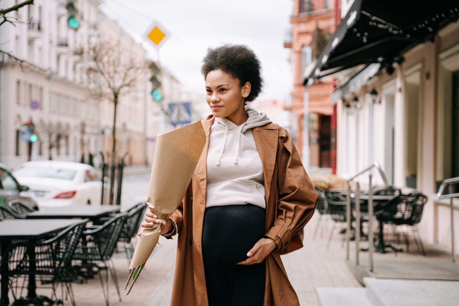 Expectant mother in leggings walking along a leafy park path