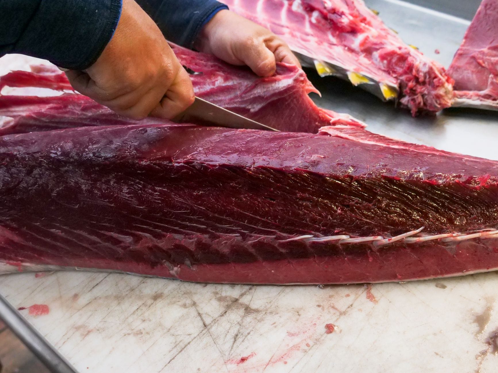 Fresh red tuna fillet on a wooden board with a knife