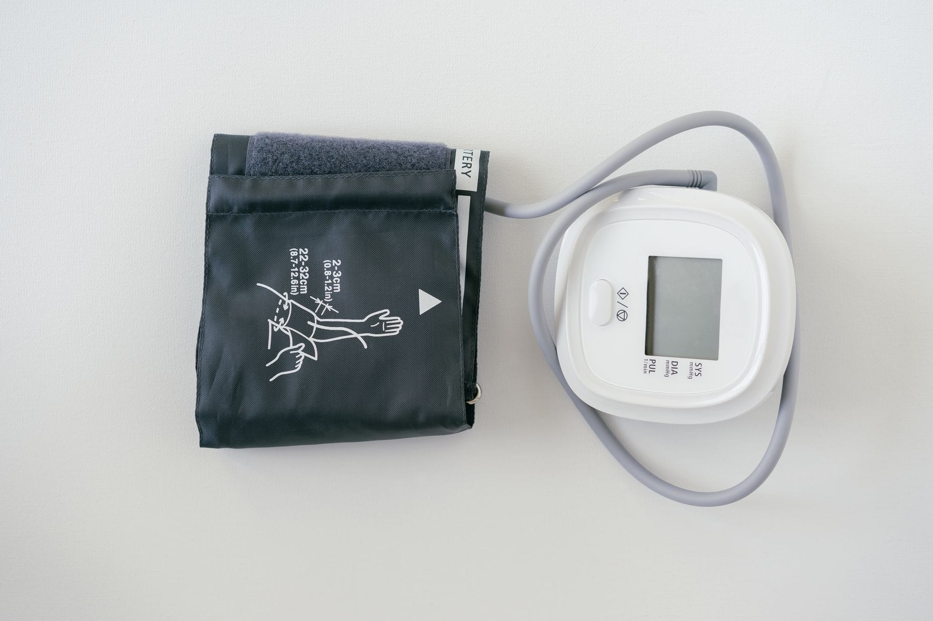 A person's arm wrapped in a blood pressure cuff during a checkup