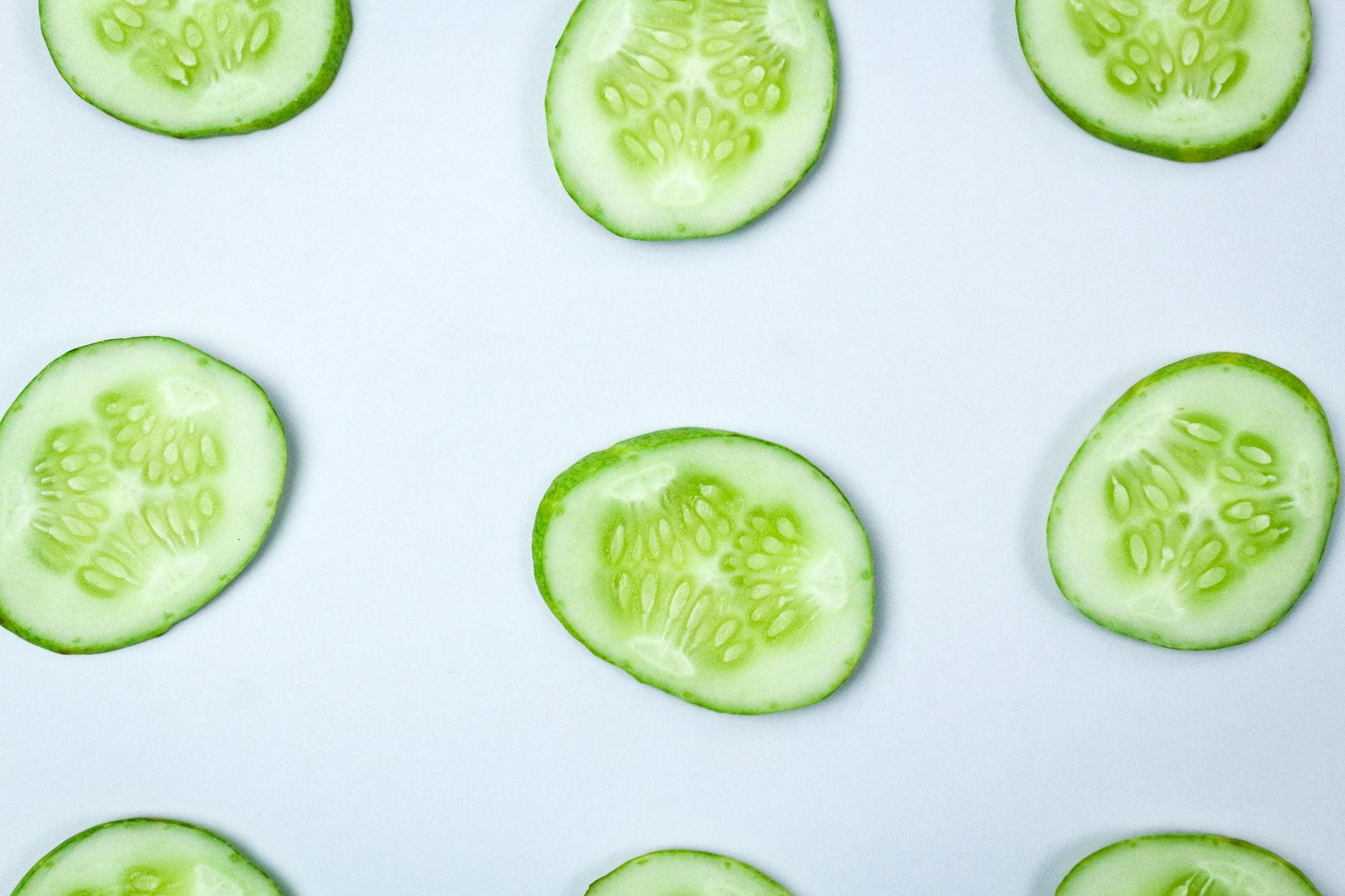 Two chilled cucumber slices resting on a white plate