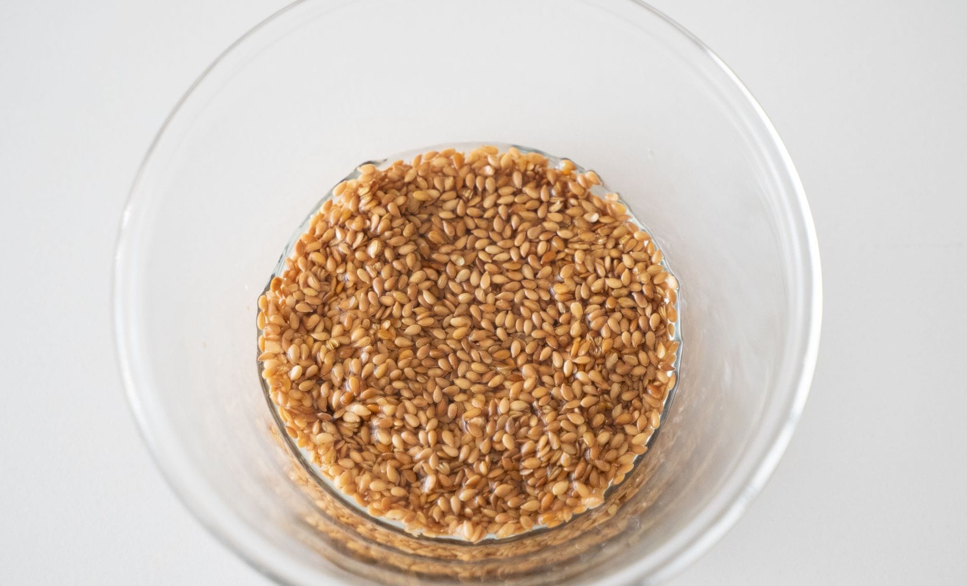 A bowl of cooked farro grains with a wooden spoon resting inside