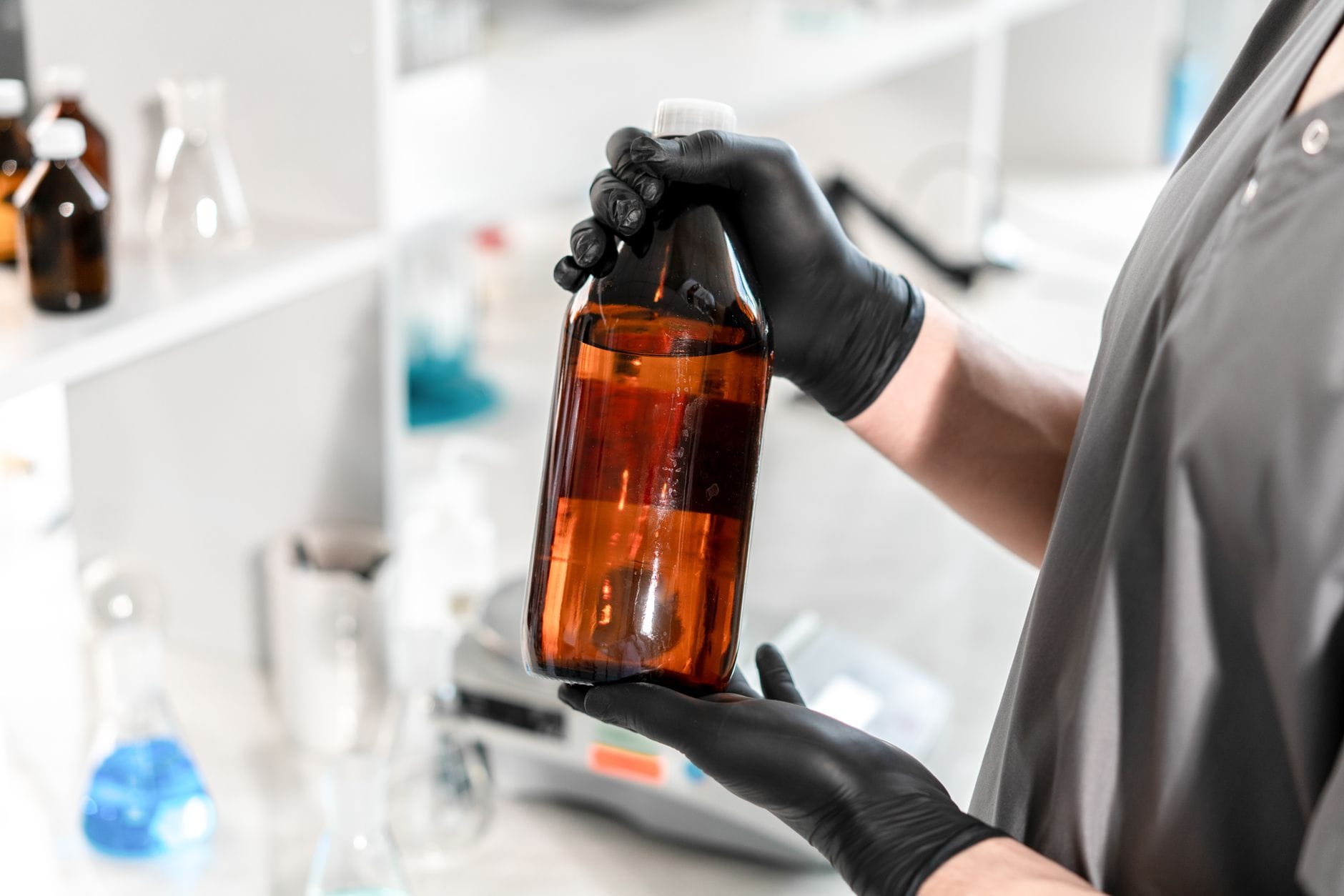 Brown glass bottle of hydrogen peroxide beside a white ceramic bowl