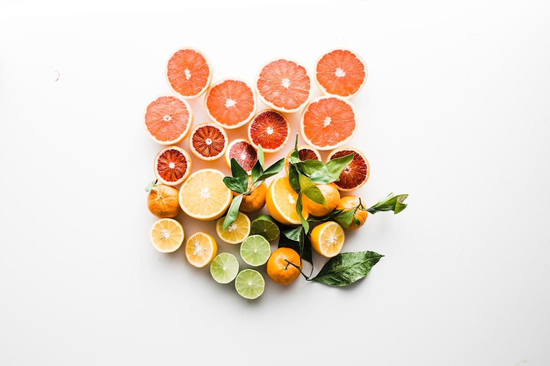 Halved oranges, lemons, and limes on a white surface