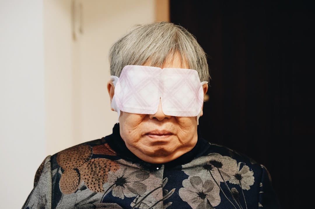 Folded white cloth resting over a closed eye during a warm compress