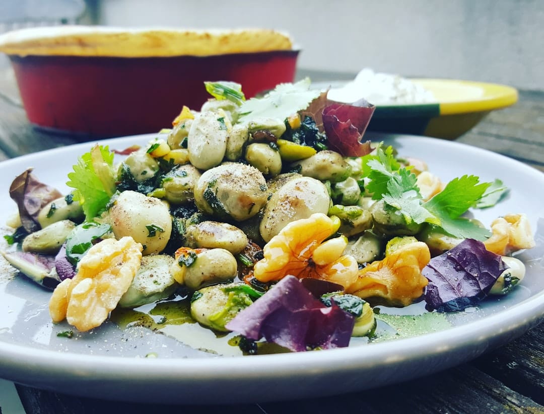 Fresh white bean salad with cherry tomatoes and greens on a plate