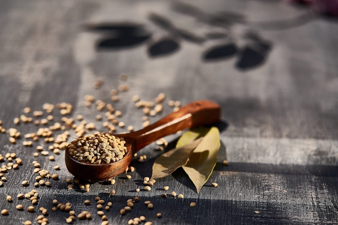 Shelled hemp seeds piled on a small wooden spoon over a linen cloth