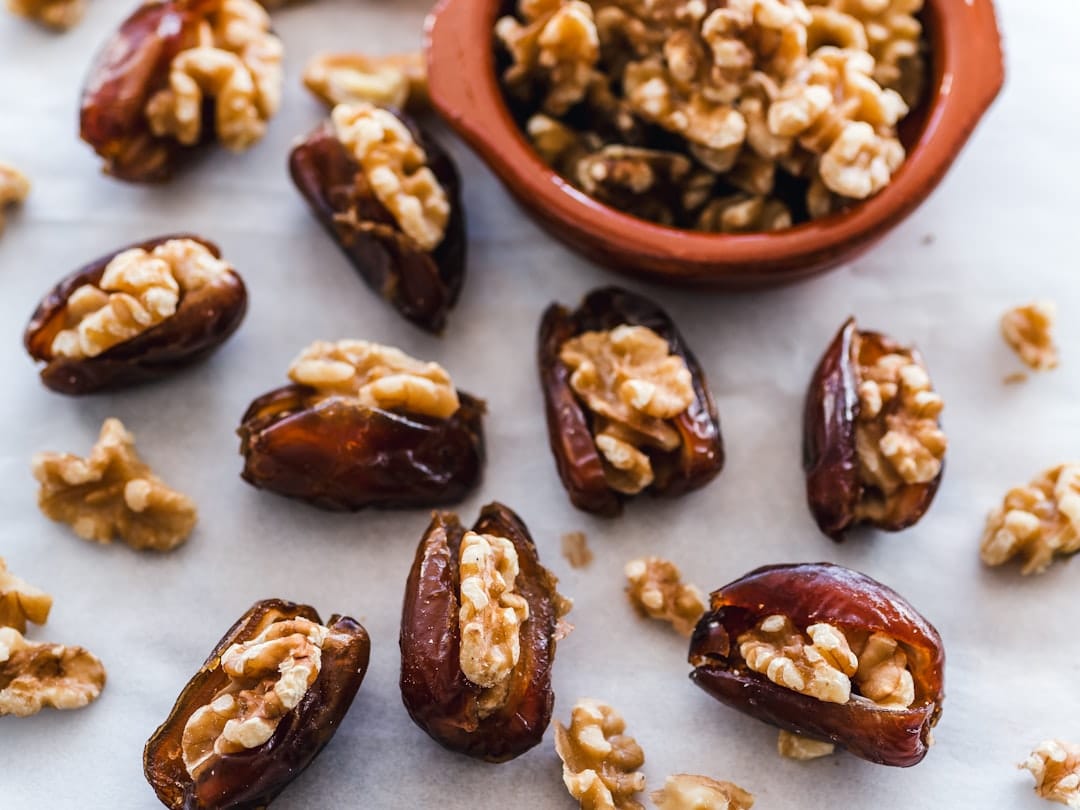 Halved dates stuffed with almonds and cheese on a slate board