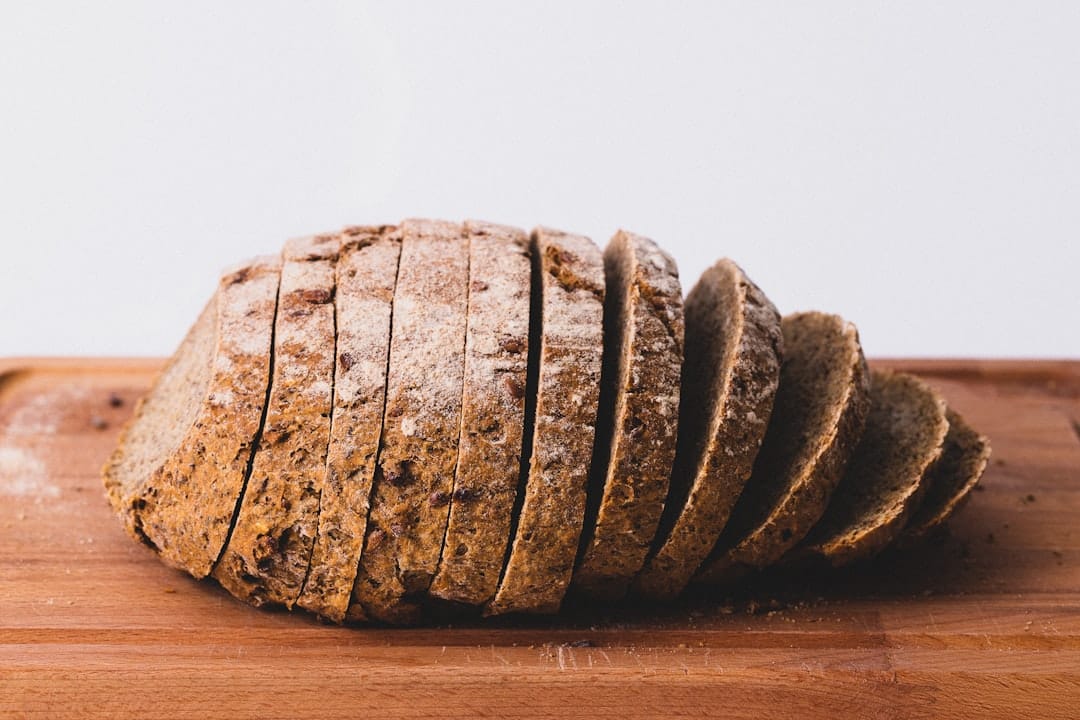 Loaf of whole-grain bread sliced on a wooden board