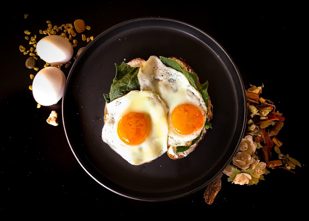 plated scrambled eggs beside fresh spinach and avocado slices