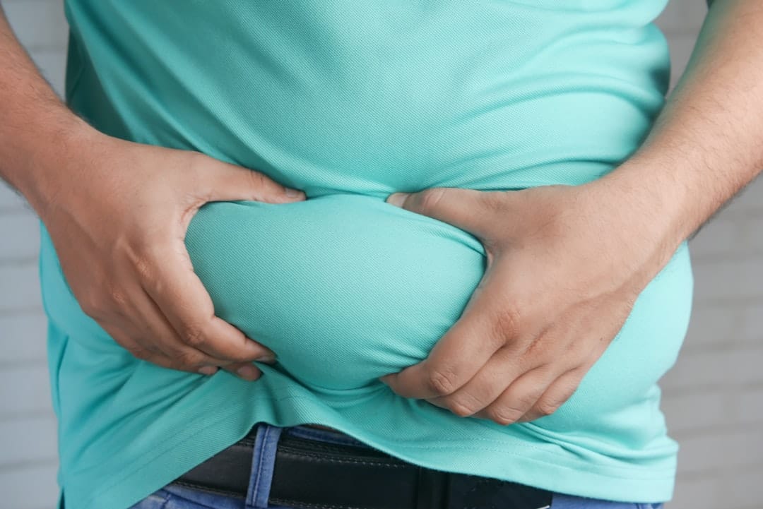 A woman pressing both hands to her stomach with a pained expression