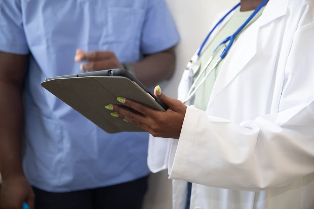 A doctor in a white coat writing notes on a clipboard