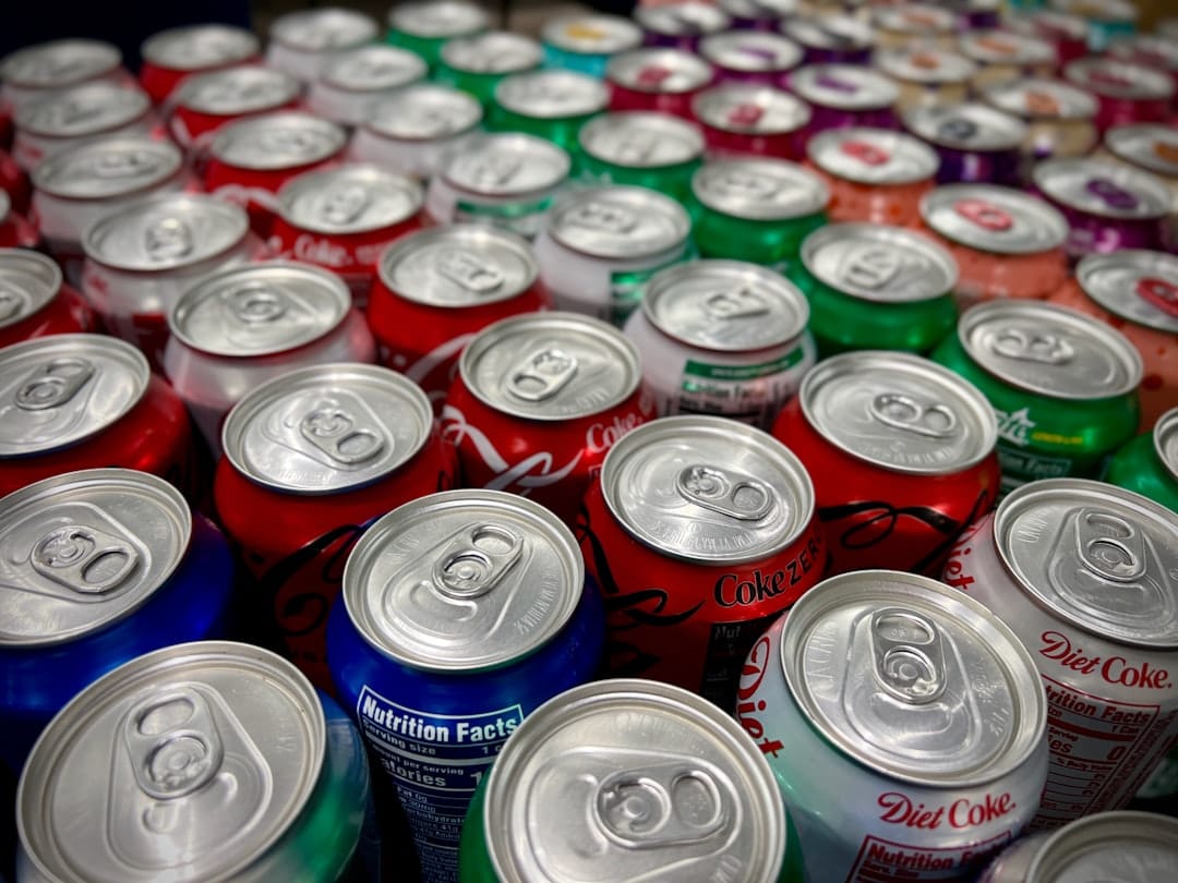 Rows of colorful sugary soda cans lined up on a shelf