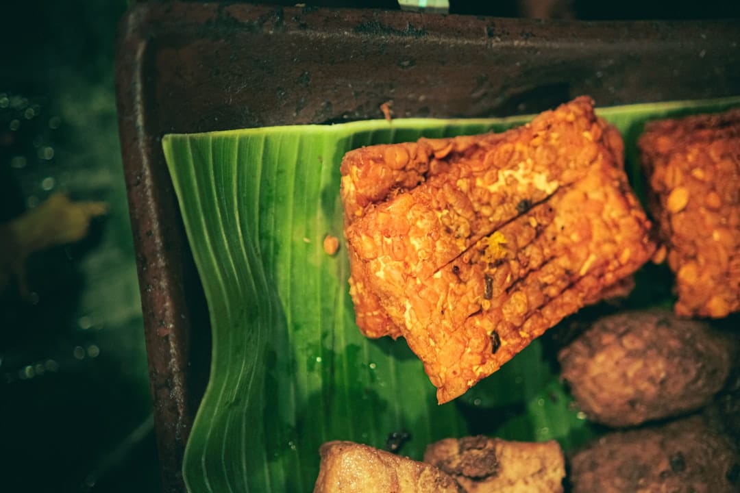 Golden pan-fried tempeh strips sizzling in a cast iron skillet