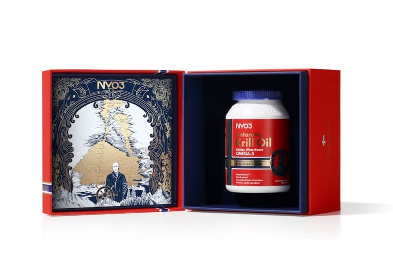 Deep red gel supplement capsules spilling from a small glass bottle onto a white surface