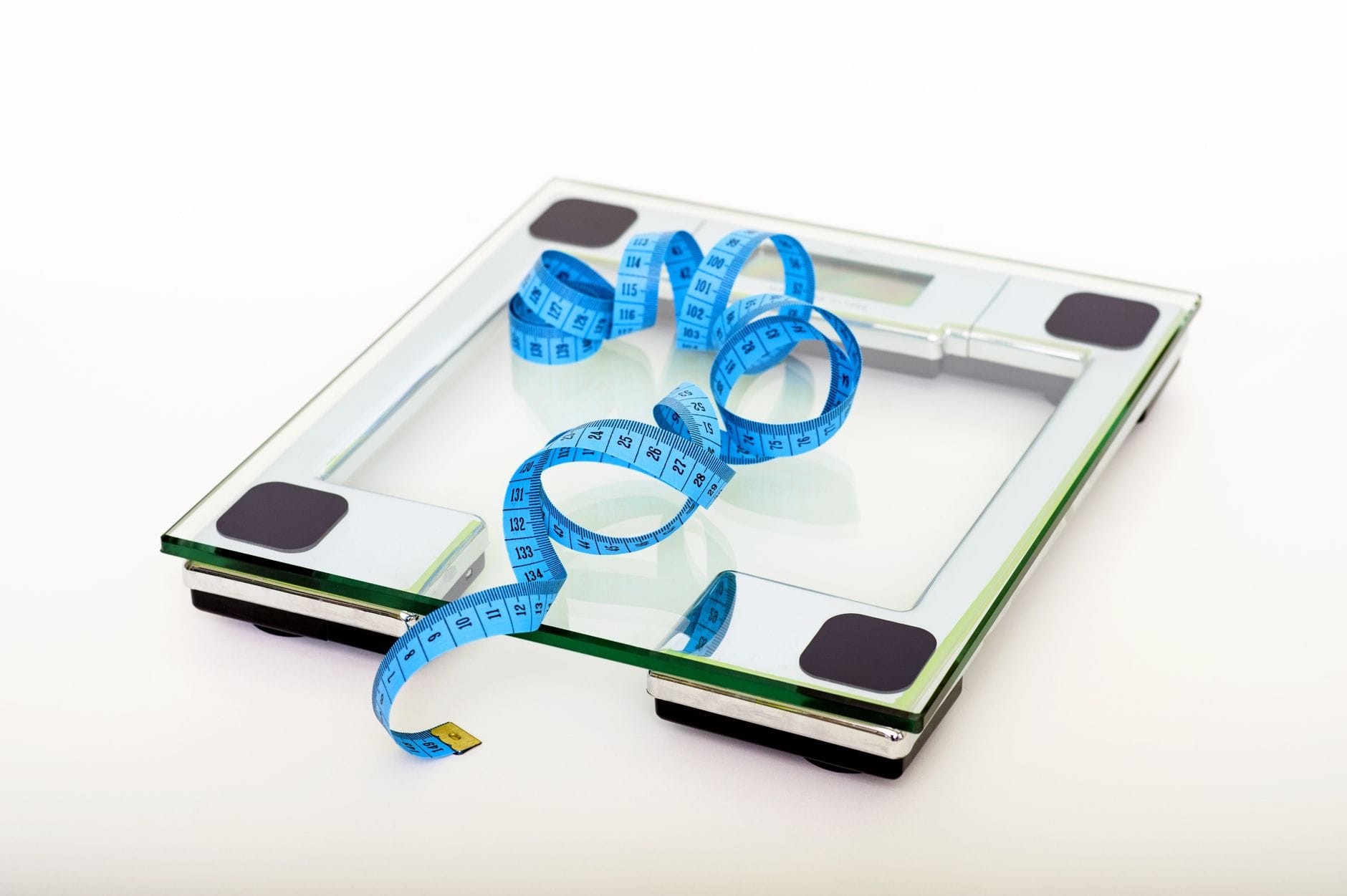 A person's bare feet standing on a digital bathroom scale