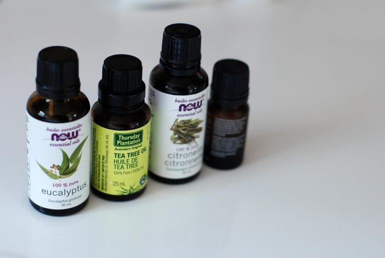 Amber glass dropper bottle of essential oil beside fresh green citronella grass