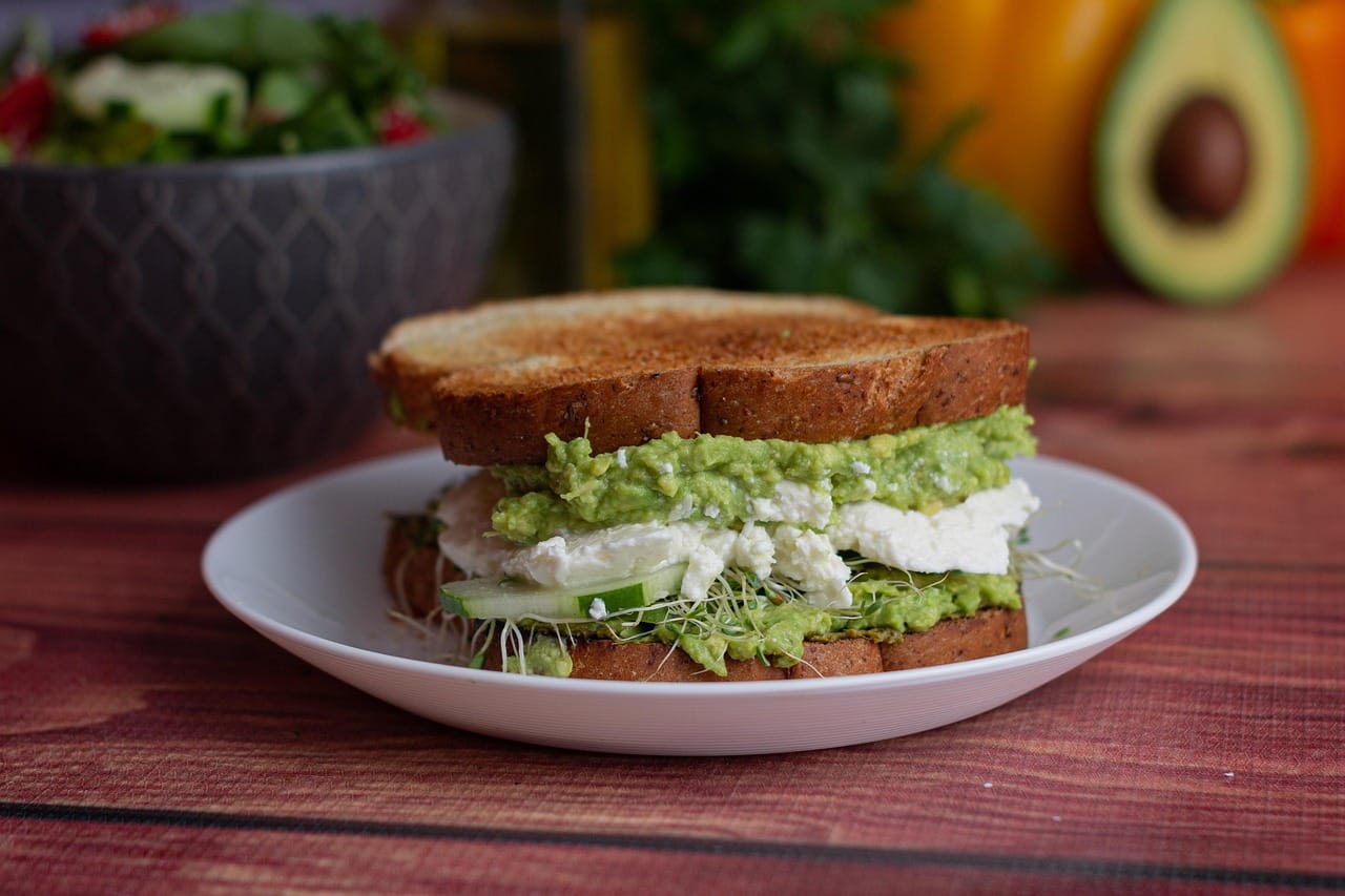 Sliced avocado spread on toasted bread with seeds on top