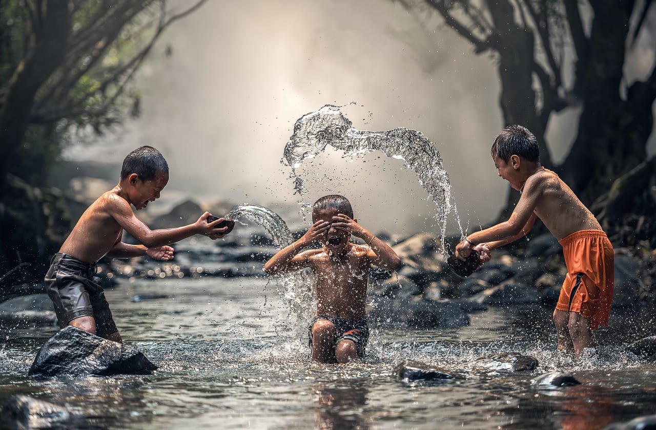Group of young children with their heads close together while playing