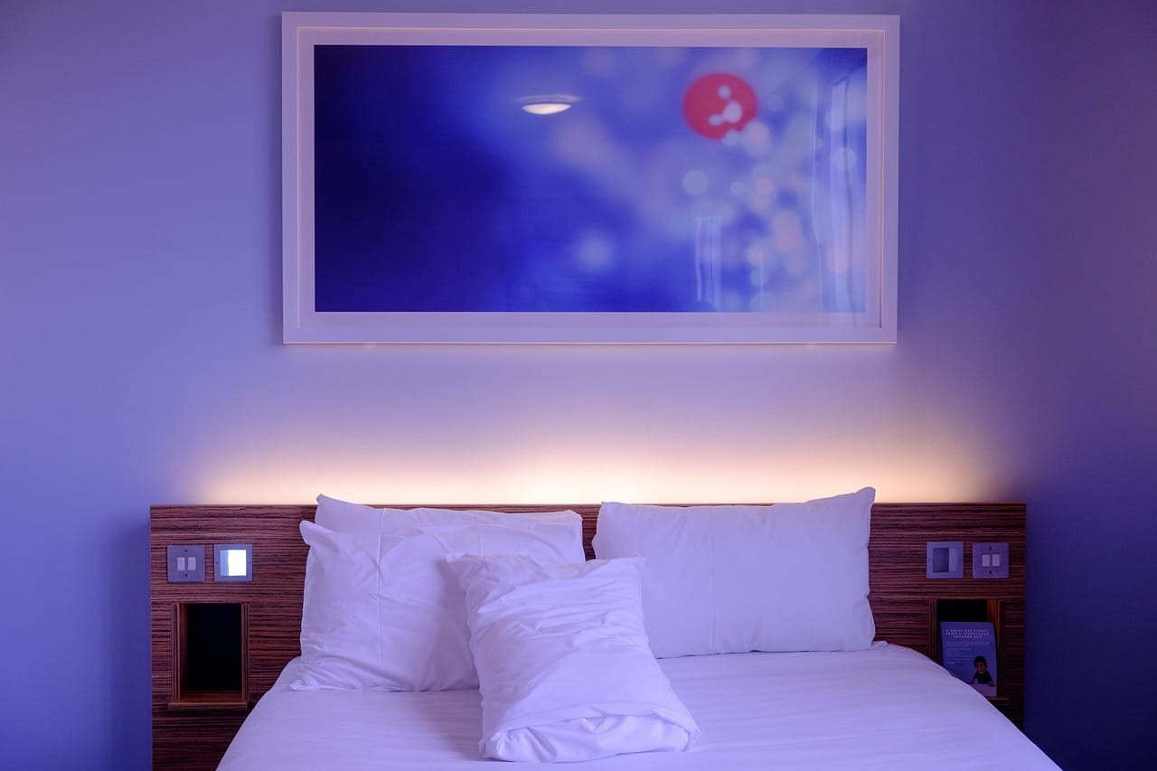 Neatly made bed with plump white pillows and folded linen