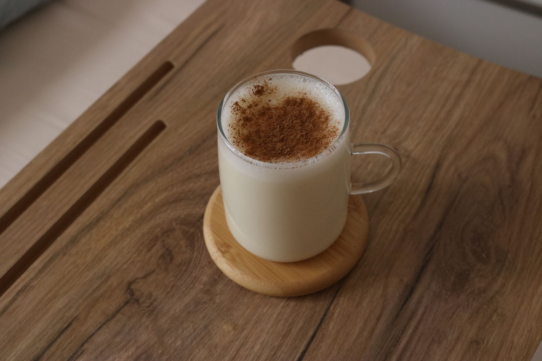 A jug of milk, a bowl of cream, and whole spices on a counter