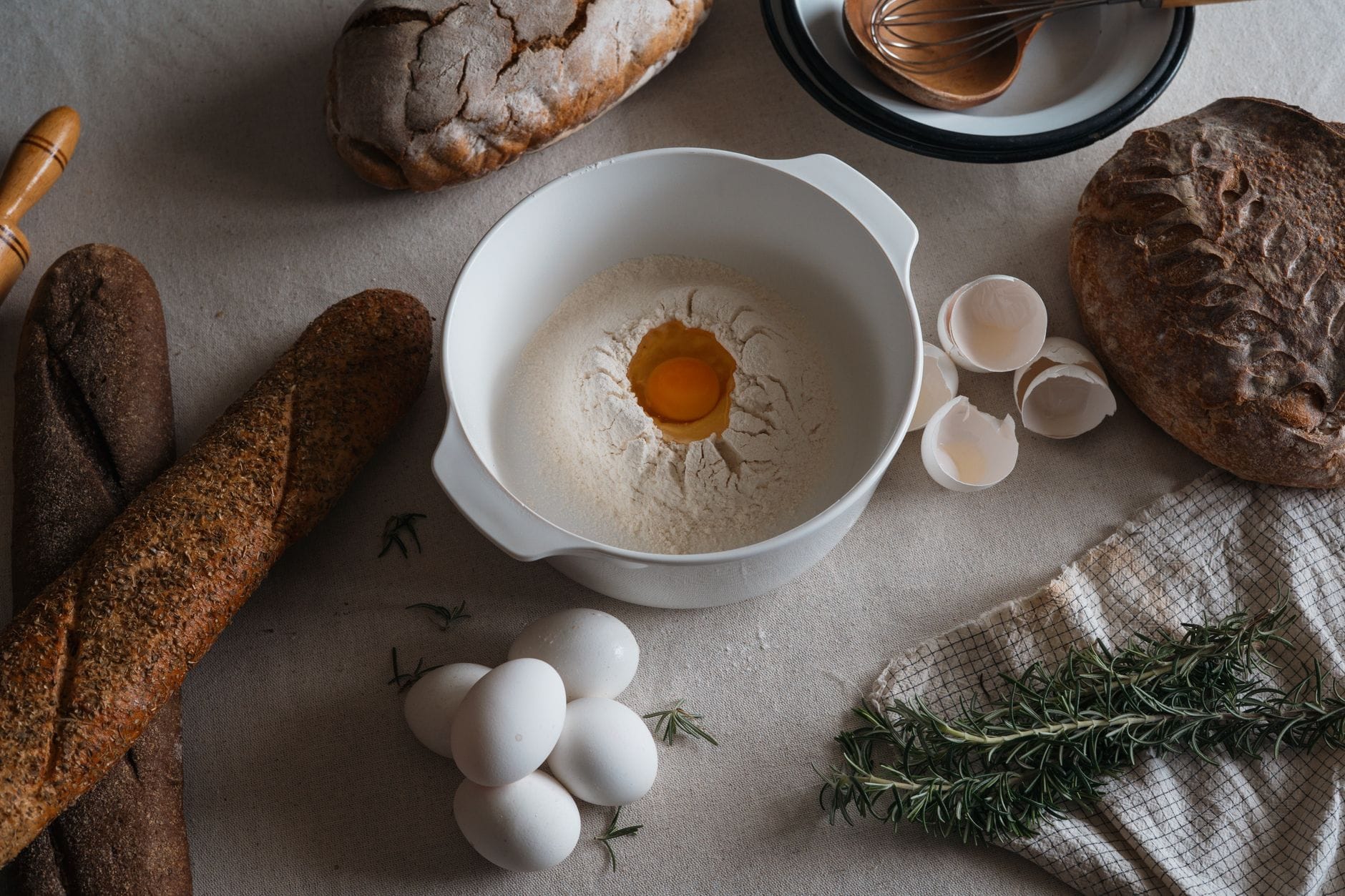 A bowl of dark rye flour with a wooden scoop resting in it