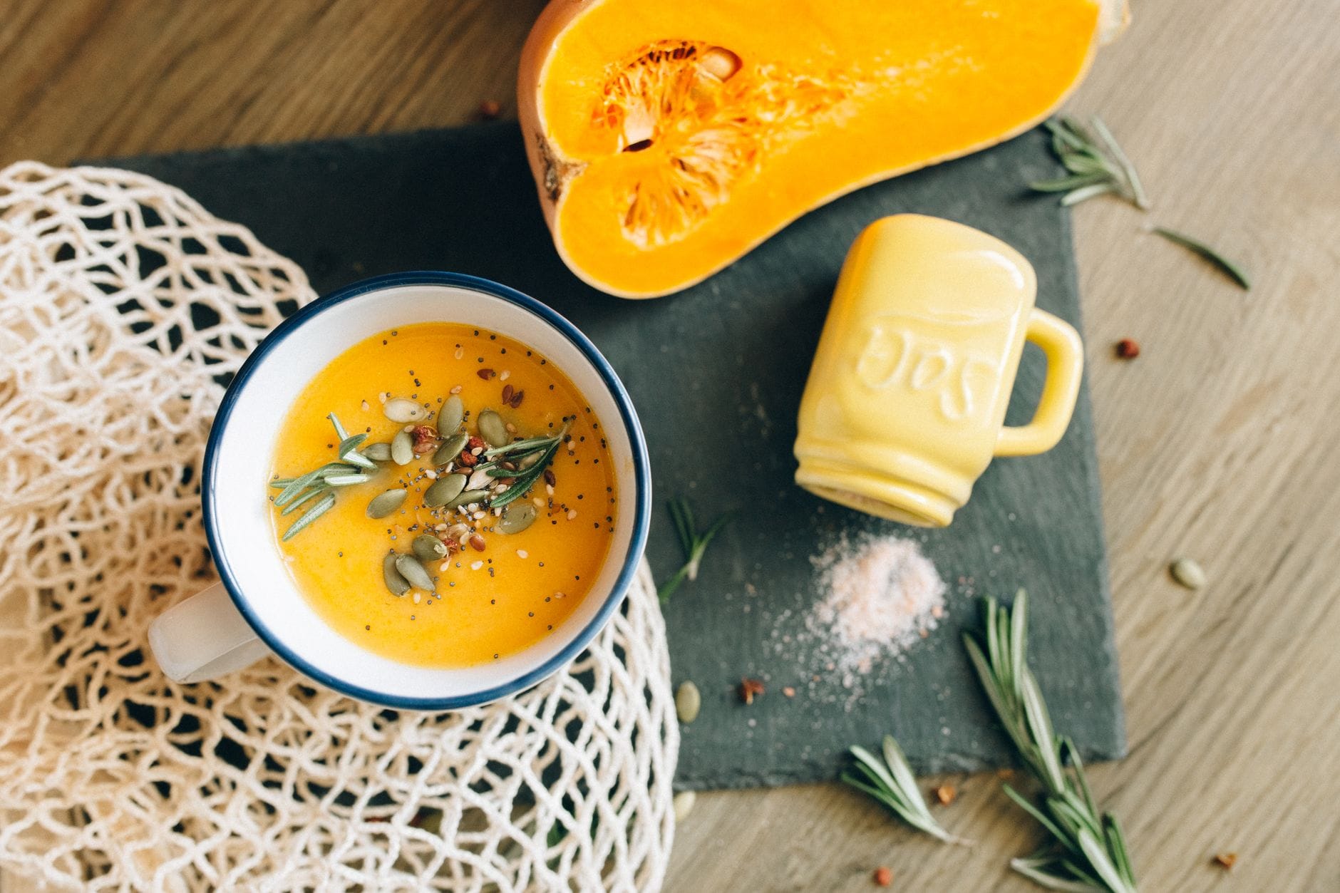 A bowl of pumpkin puree surrounded by cinnamon sticks and whole spices