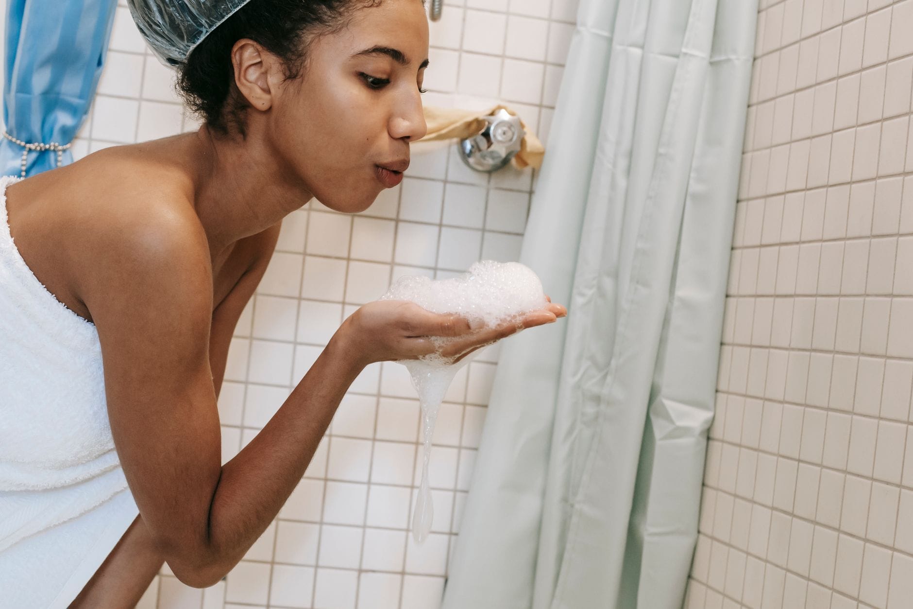 A person wearing a plastic shower cap over freshly treated hair