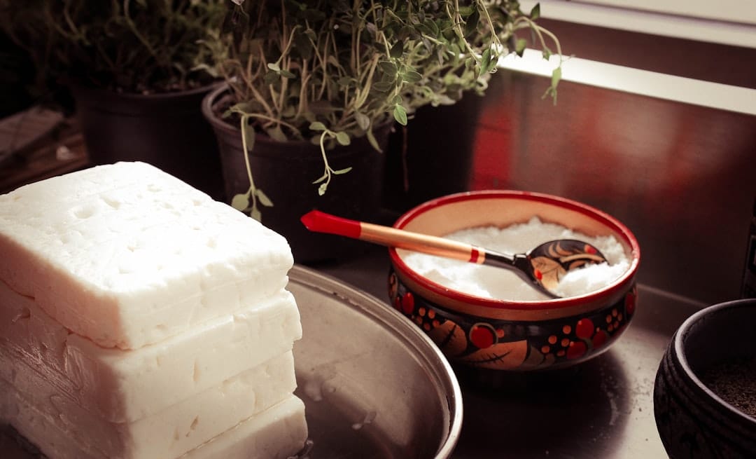 Fresh cottage cheese in a white ceramic bowl with a spoon