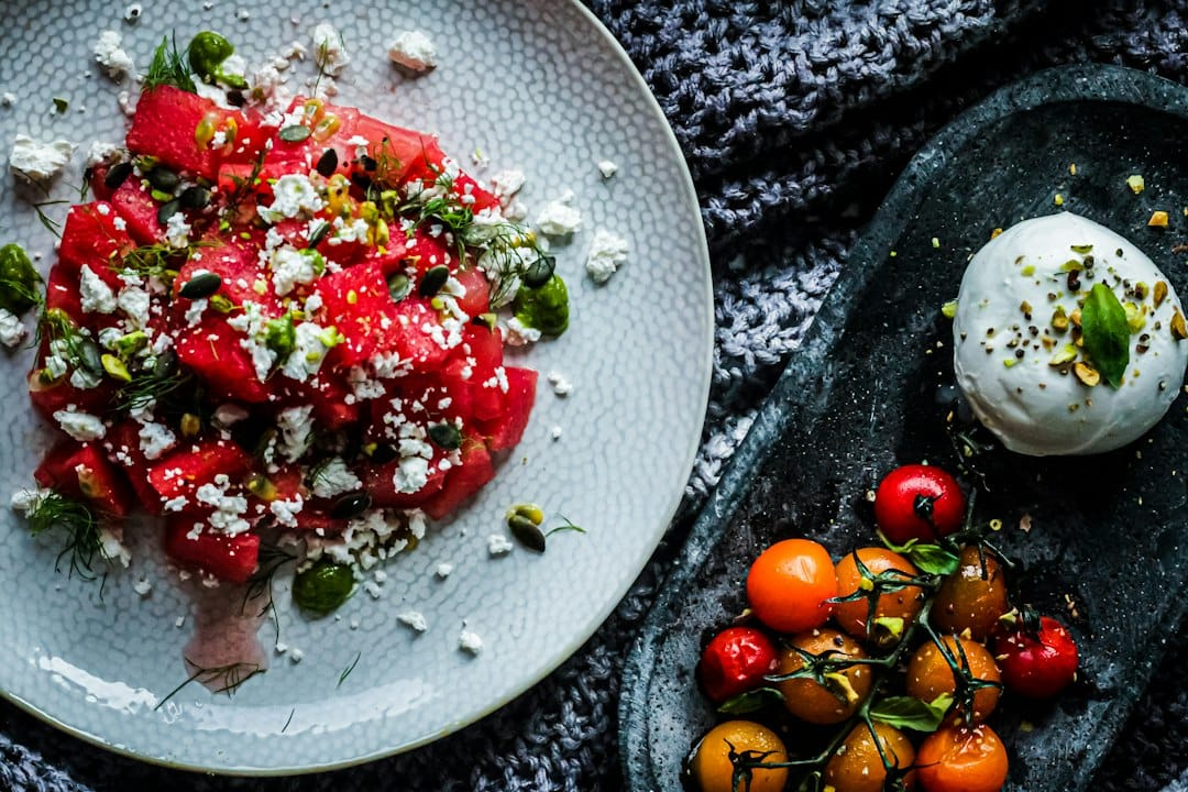 A bowl of cubed watermelon tossed with crumbled feta and fresh mint leaves