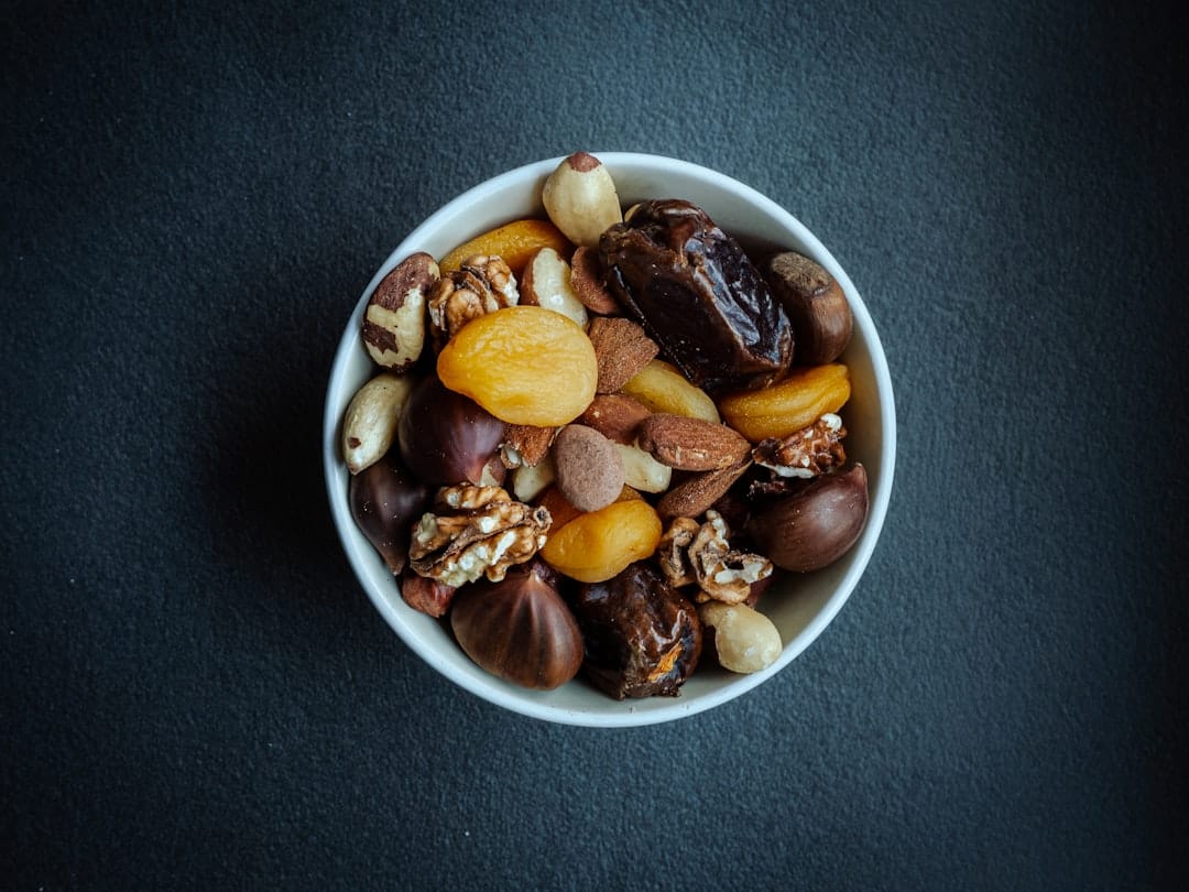 A large bowl of crunchy snack mix with cereal squares, pretzels, and nuts